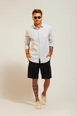 Camisa blanca de vestir con finas rayas verticales celestes, de corte clásico y manga larga.