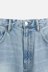 Pantalón de jean celeste con efecto lavado, corte amplio tipo baggy y cinco bolsillos.