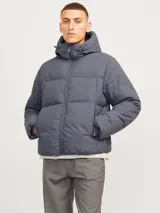 Campera puffer gris con capucha ajustable y bolsillos frontales.