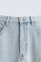 Pantalón de jean azul de corte recto, con cinco bolsillos, efecto lavado y cierre frontal con botonadura.