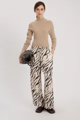 Pantalón de corte relajado con estampado de cebra en tonos beige y negro.