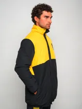 Parka de hombre bicolor negra y amarilla con escudo del club deportivo Peñarol en el pecho.