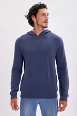 Buzo azul de punto con capucha y mangas largas.