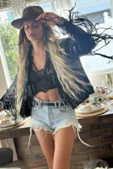 Campera negra de lentejuelas con flecos largos en mangas y ruedo.