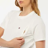 Camiseta blanca de manga corta para maternidad con un pequeño corazón bordado en el pecho.