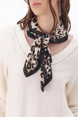 Pañuelo cuadrado con estampado animal print en tonos beige y negro, con borde negro liso.
