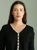 Saco de algodón verde con aberturas en hombros y codos, de corte entallado. Tiene cuello en V, botones pequeños y plaqueta de tejido puño color crudo.