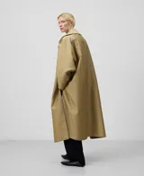 Gabardina larga color beige con interior gris, de tejido a rayas verticales. Tiene mangas largas amplias, cierre frontal cruzado con botones, bolsillos delanteros y aberturas laterales.