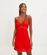 Vestido corto rojo de lino con tirantes dobles y costuras en contraste. Tiene una abertura debajo del busto y pespuntes vistos en el ruedo.