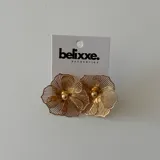 Par de aros colgantes con forma de flor calada, disponibles en plateado y dorado.