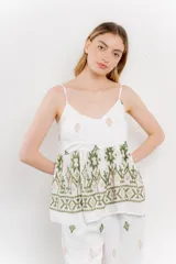 Blusa blanca de algodón con bordados artesanales en verde y corte suelto.