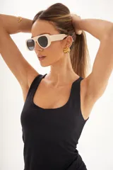 Lentes de sol con montura de acetato color crema y lentes oscuros con protección UV400.