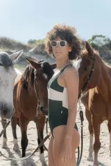 Traje de baño enterizo color verde inglés con banda horizontal blanca en el torso.