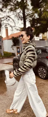 Campera puffer cropped negra con mangas y capucha de polar estampado con diseño geométrico en tonos beige, marrón y negro.