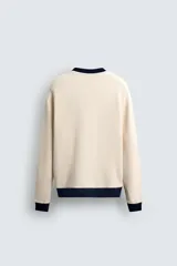 Sudadera de hombre color crudo con estructura waffle, corte relaxed fit, cuello redondo, manga larga y ribete en cuello, puños y bajo en color azul marino.