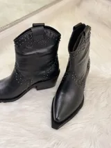 Botas cortas negras de cuero con punta fina, taco cuadrado y apliques de tachas plateadas.