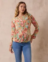 Blusa de gasa estampada a rayas verticales en tonos celeste, lila, naranja y marrón. Tiene cuello a la base con escote en V y botones. Delantera con bolsillo aplicado. Largo de manga regulable con presilla y botón. Terminación anudada opcional.