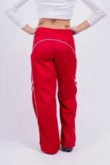 Pantalón deportivo rojo con detalles de líneas blancas curvas en los laterales.
