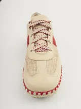 Championes de cuero color beige con detalles en rojo, suela de yute y cordones con diseño trenzado.