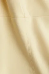 Musculosa color crema con breteles anchos, escote cuadrado, pinzas en el busto y cintura entallada con costuras visibles.