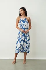 Vestido midi con estampado abstracto en tonos naranja y blanco, breteles finos y corte evasé.