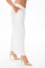 Pantalón palazzo blanco con estampado de hojas doradas, con bolsillos laterales y corte holgado.