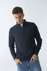 Buzo negro de algodón con cuello alto y medio cierre. Tiene logo bordado en el pecho y puños en las mangas.