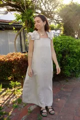 Vestido largo color cemento, confeccionado en lino 100%, de corte recto, con breteles anchos con volados y espalda regulable.