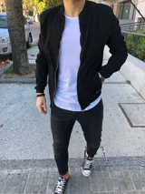 Campera bomber negra de gabardina con cierre frontal y bolsillos laterales.