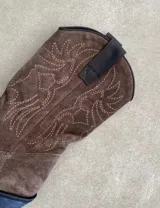 Botas de cuero negro con bordado decorativo en el caño y empeine, taco bajo y punta fina. Diseño de estilo cowboy.