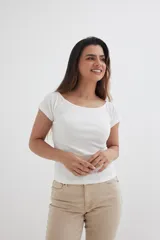 Remera blanca de algodón con elastano, mangas cortas y escote off shoulder.