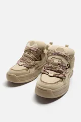 Zapatilla deportiva color beige, estilo skate. Capellada fabricada en combinación de piezas y materiales. Lengüeta acolchada. Detalle de cordones de cuerda. Tirador trasero para facilitar el calce. Suela con volumen y diseño irregular.