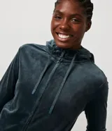 Campera deportiva gris de plush con capucha, cierre frontal y bolsillos laterales.