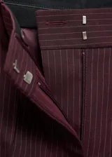 Pantalón de vestir color borgoña con finas rayas verticales, tiro medio, corte recto y bolsillos laterales.