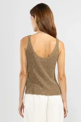 Musculosa sin mangas tejida en Italia en punto canalé con mezcla de viscosa e hilos metálicos Lurex color dorado. Con escote bote y calce cómodo.