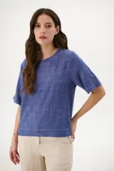 Blusa color crudo de lino con cuello redondo y mangas cortas.