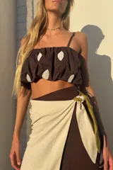 Top tipo balloon de color marrón con estampado de formas ovaladas blancas, breteles finos y elástico en el bajo que genera un efecto abullonado.