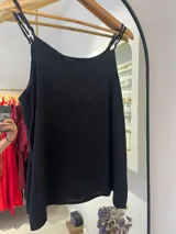 Musculosa negra con tirantes finos ajustables y un diseño bordado o estampado tono sobre tono en la parte superior del pecho.