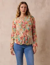 Blusa de gasa estampada a rayas verticales en tonos celeste, lila, naranja y marrón. Tiene cuello a la base con escote en V y botones. Delantera con bolsillo aplicado. Largo de manga regulable con presilla y botón. Terminación anudada opcional.