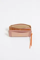 Monedero negro de piel con estructura rígida, logo metálico dorado, tirador de cordón y acabados metálicos dorados. Tarjetero interior, cierre con botón de presión e interior con logo grabado. Confeccionada en 100% poliéster reciclado y 100% poliuretano de producción responsable.