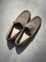 Mocasines de cuero color marrón topo, con suela de goma y detalle de antifaz con costuras en la capellada.
