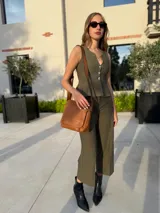 Bandolera de hombro color gris claro, con solapa frontal y correa ajustable. Presenta un diseño simple y práctico, ideal para uso diario.