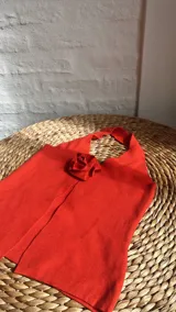 Top rojo con cuello halter y abertura frontal con detalle de rosa.