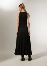 Vestido negro sin mangas de poliéster, corte al cuerpo, largo midi con abertura lateral y cuello redondo.