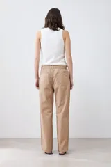 Pantalón de gabardina color tostado, de corte recto, con bolsillos laterales y traseros. Se ajusta a la cintura con cinturón de cuero con estampado animal print.