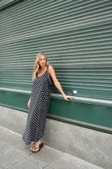 Vestido largo negro con lunares blancos, de breteles finos y corte amplio.