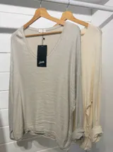 Blusa de manga larga color crema con lentejuelas.