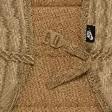Mochila Nike Heritage Eugene color beige con logo blanco estampado en el frente. Cuenta con un compartimento principal con cierre de doble cremallera, un bolsillo frontal con cierre y un bolsillo lateral abierto. Tiene correas acolchadas ajustables y asa de mano en la parte superior.
