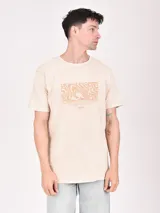 Remera color beige con estampa rectangular con diseño abstracto en tonos marrones y texto.
