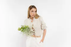 Blusa color blanco de lino, con mangas 3/4 y volados en el frente. Se ata con lazos en el centro.